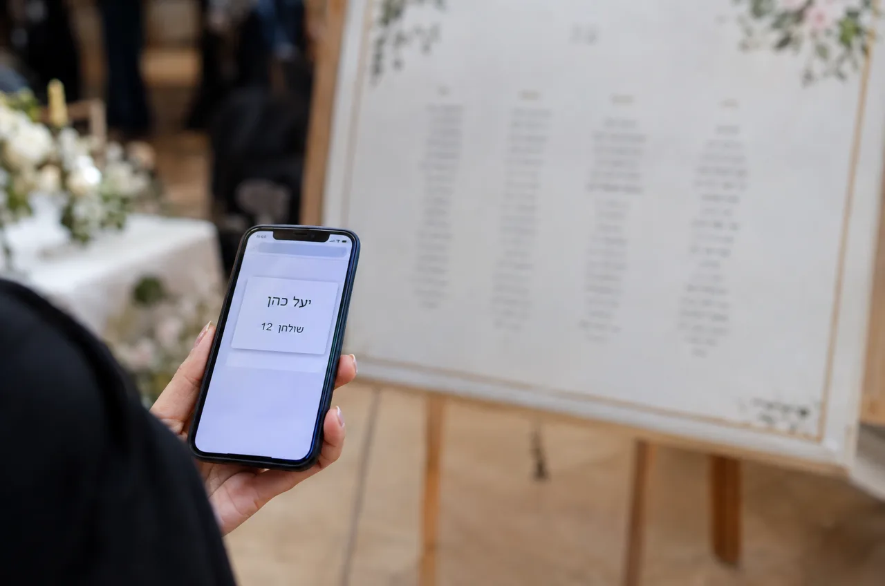 אורח מוצא את מקום הישיבה שלו באמצעות לוח הושבה דיגיטלי בטלפון הנייד.